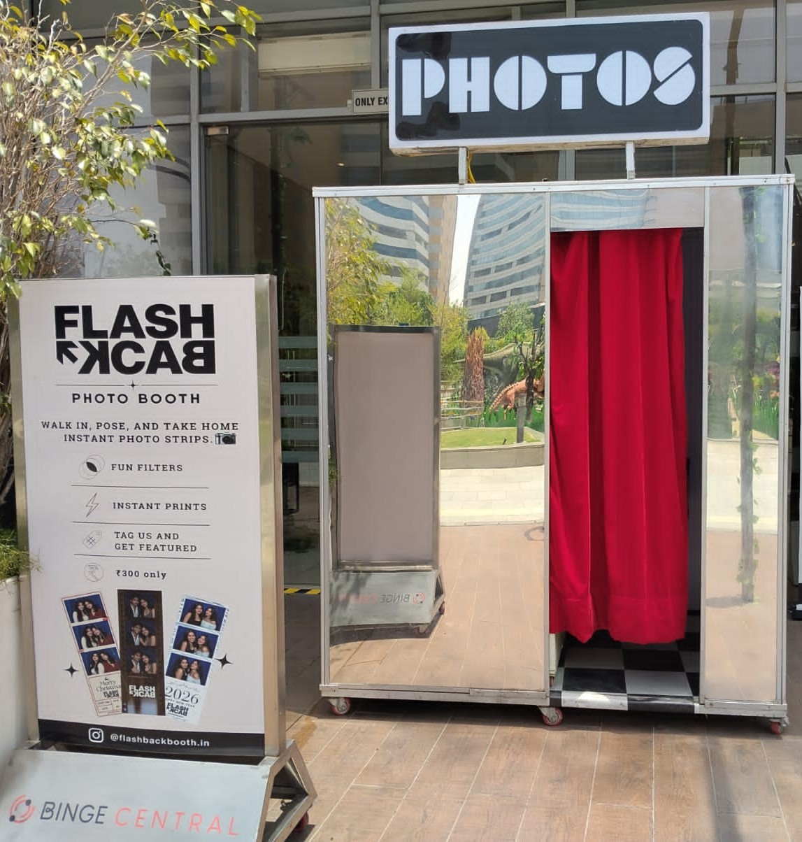 Flashback photo booth setup with red curtain and printed strip samples